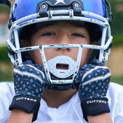 Lifestyle Image of Youth Football Player Wearing Black/White Lux Rev 5.0 Limited-Edition Youth Receiver Gloves