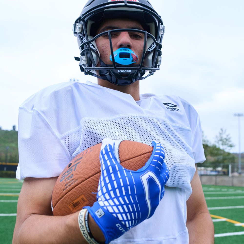 Lifestyle Image of Youth Football Player Wearing Rev 5.0 Receiver Gloves in Royal Blue