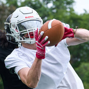 Lifestyle Image of Youth Football Player Wearing Rev 5.0 Receiver Gloves in Red