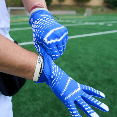 Lifestyle Image of Youth Football Player Wearing Rev 5.0 Receiver Gloves in Royal Blue