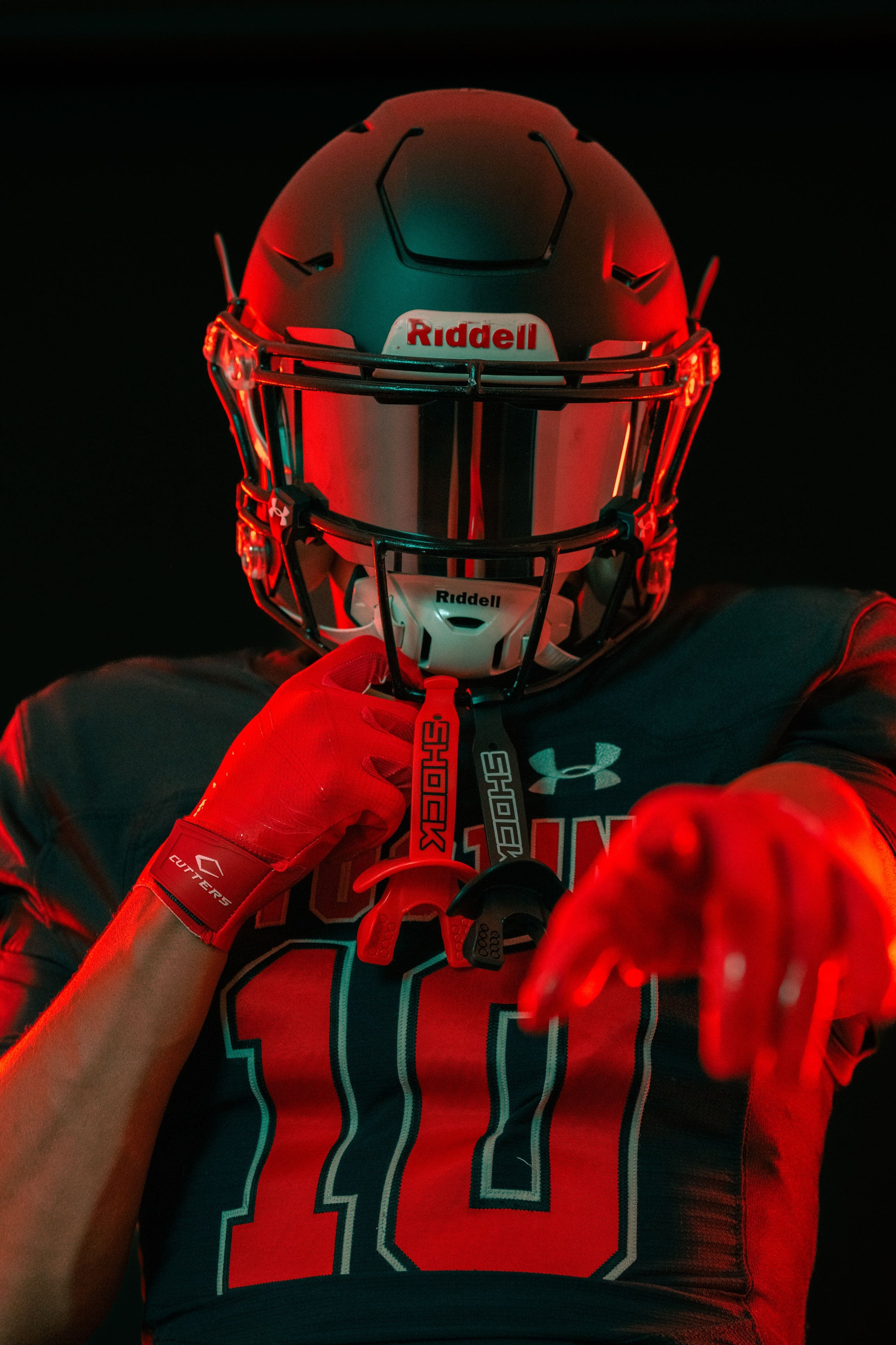 Tackle Football Athlete Showcasing Cutters Rev Pro 6.0 Gloves and Shock Doctor Lip Guards