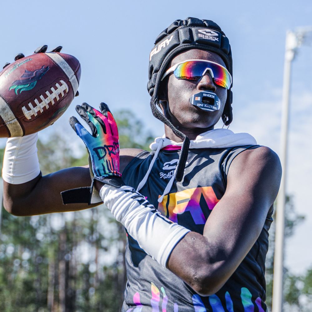 Youth Football Player Wearing Cutters Sports Tie Dye Rev Pro 4.0 Limited Edition Receiver Gloves