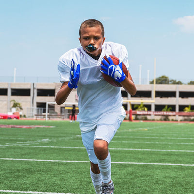 Youth Football Player Wearing Cutters Sports Royal Blue Rev 4.0 Receiver Gloves